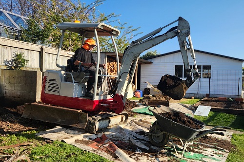 2t digger loading earth into a wheel barrow