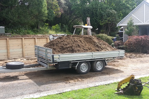 2T Digging's tipping trailer load with earth.