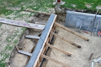 Sunken courtyard dug out, walls boxed up and concrete
                     poured.